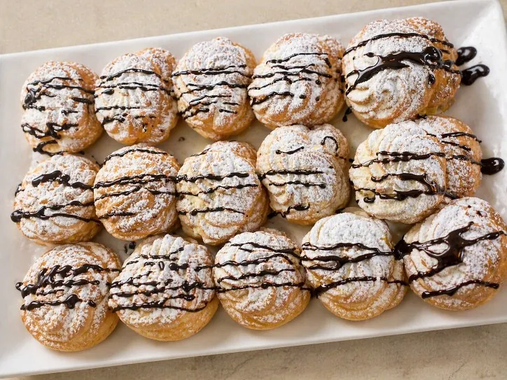 Bignè con panna e glassa al cioccolato pronti per il servizio