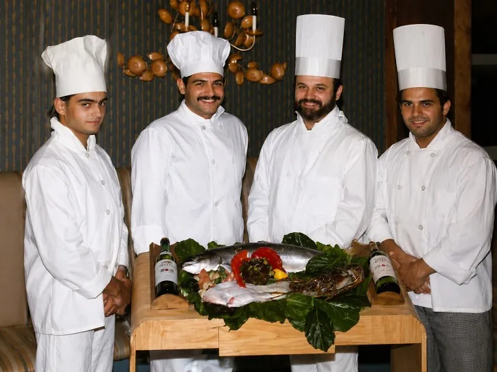 Chef Nando Santoro con la brigata di cucina e il pescato del giorno