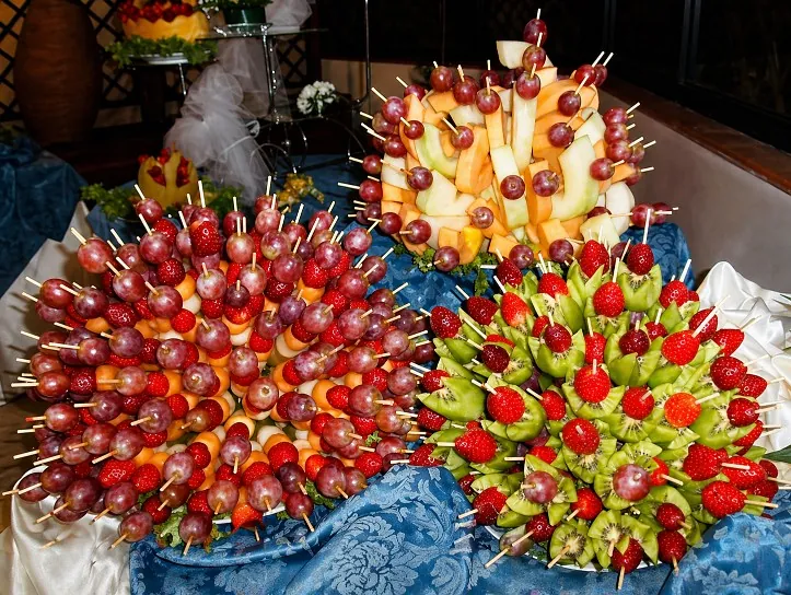 Composizione scenografica di spiedini di frutta fresca per un buffet di cerimonia